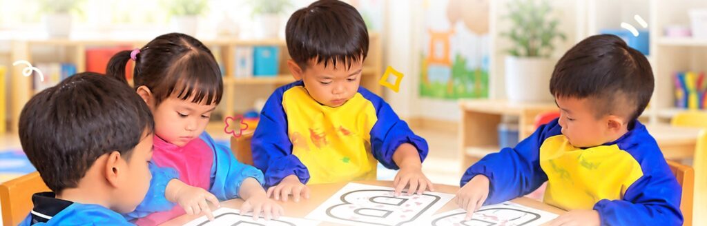 Toddlers tracing letters together at a playgroup table